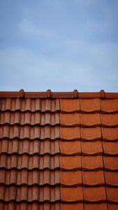 Close-up view of a tiled roof contrasting with a clear blue sky.